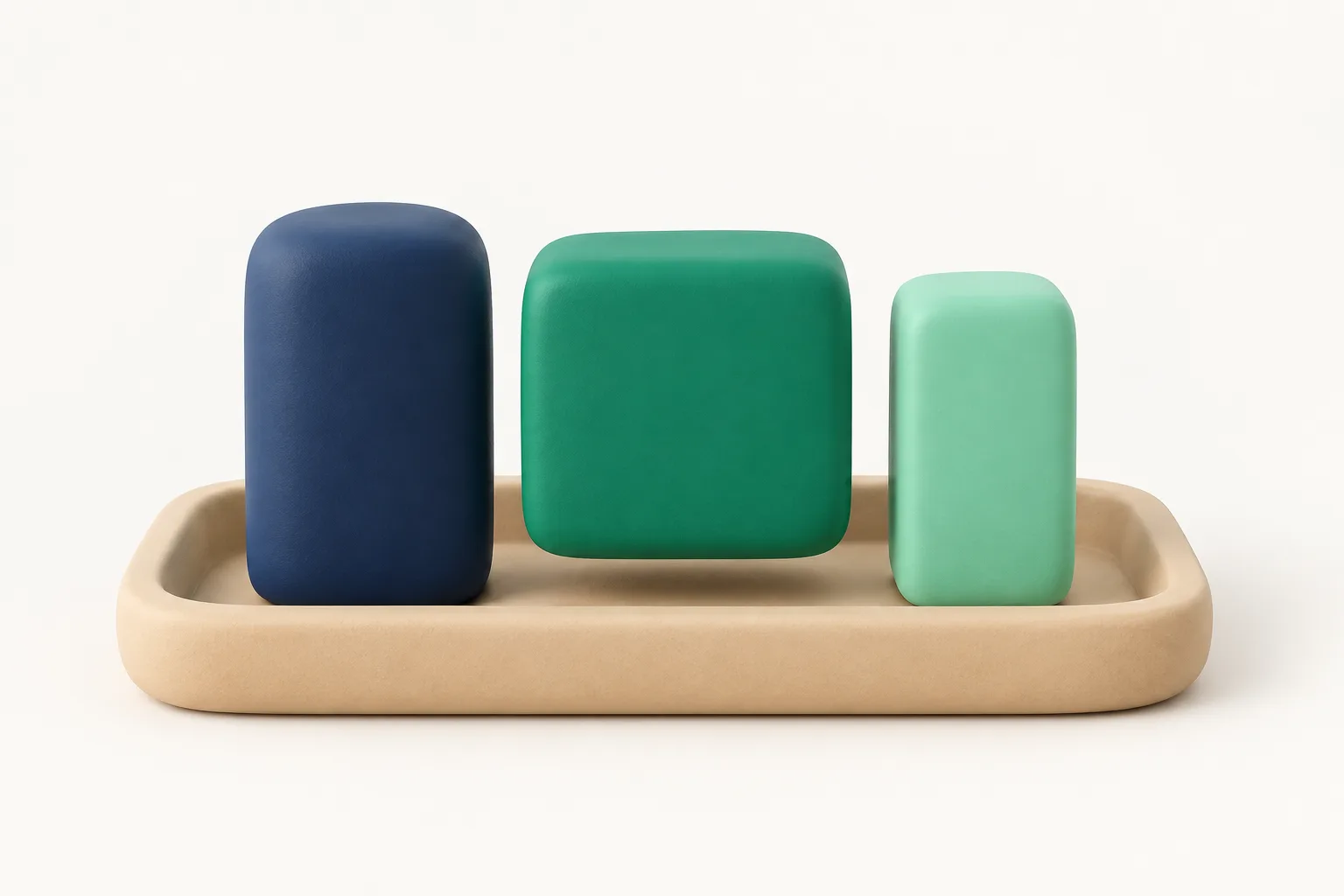 Three clay printing blocks of different shapes on a tray, with one emerald block lifted slightly above the others, showing one font picked from a set